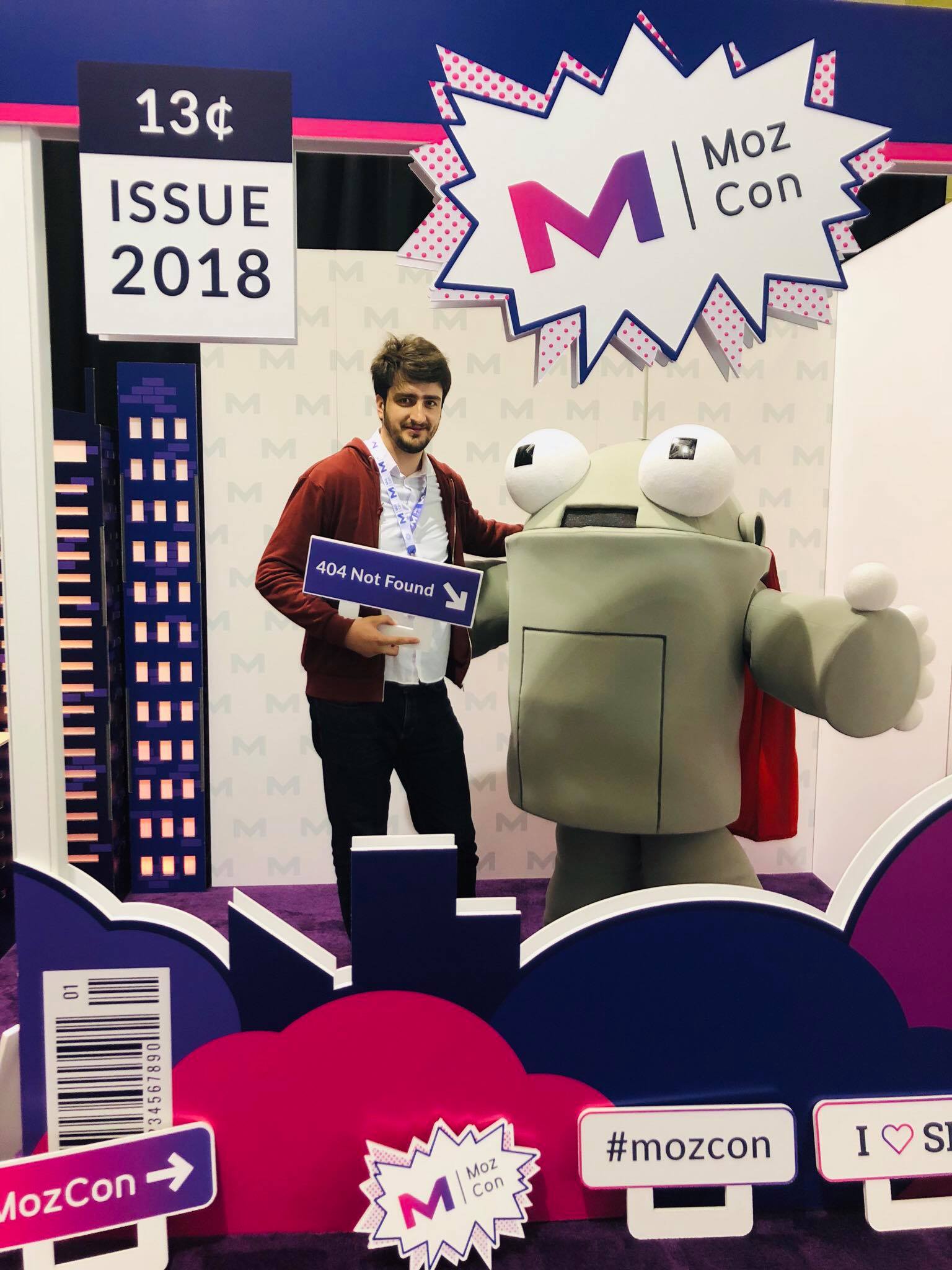 Me posing with Roger the Mozbot, the MozCon robot mascot, holding a "404 Not Found" sign at the conference photo booth.